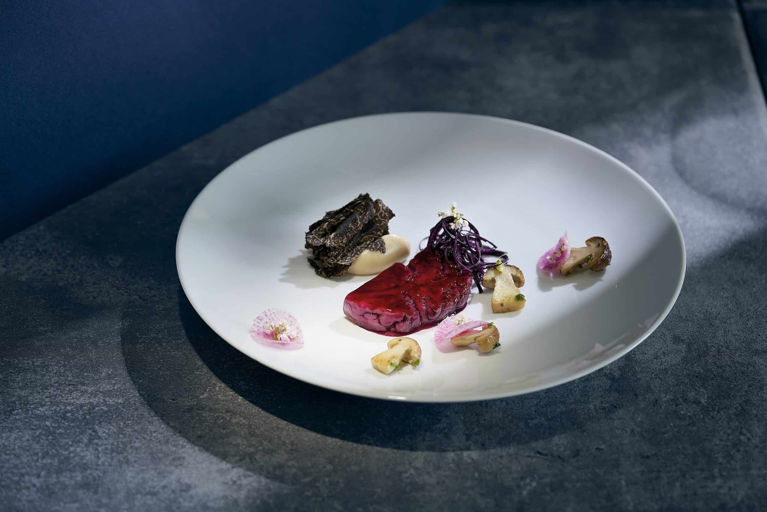Vendôme_Geröstetes-Kalbshirn-und-Fermentierter-Rotkohl-Sellerie-Tahin-eingelegte-Steinpilze-schwarzer-Trüffel_c_Erik-Chmil-scaled