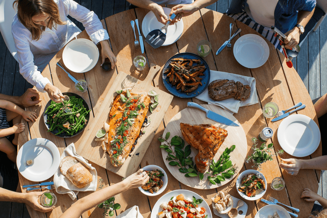 Großer Holztisch mit unterschiedlichen Gerichten in kleinen Schüsseln